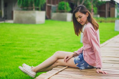 Bambu köprüde oturan kadın