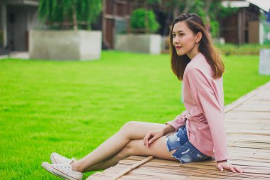 Bambu köprüde oturan kadın