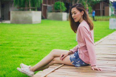 Bambu köprüde oturan kadın