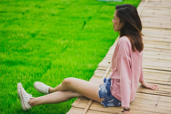 Bambu köprüde oturan kadın