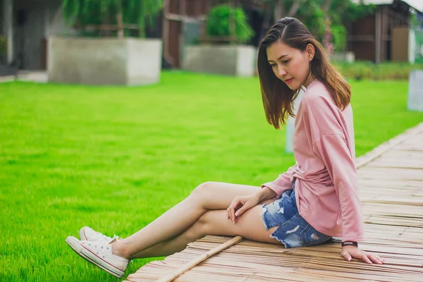 Bambu köprüde oturan kadın