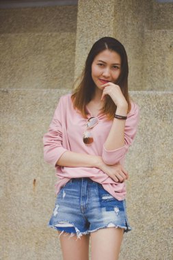 Çimento duvar ile duran kadın.