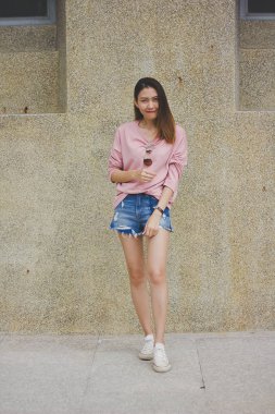 Çimento duvar ile duran kadın.