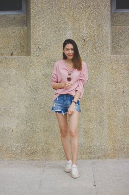 Çimento duvar ile duran kadın.