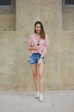 Çimento duvar ile duran kadın.