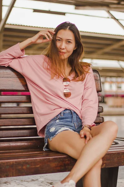 Woman sitting in a chair in a train station