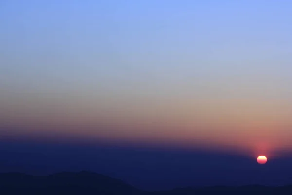 山頂に沈む夕日のオレンジ色の光 — ストック写真