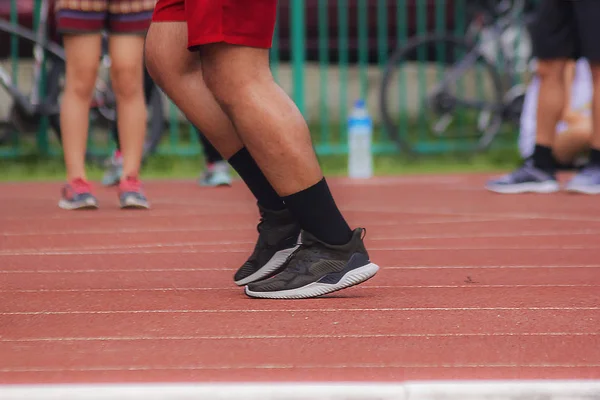 Legs of men running in the running track.