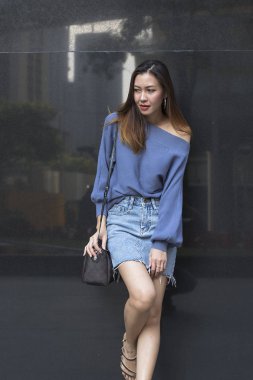 Gri granit duvara karşı duran genç bir kadın