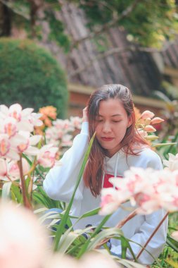 Women are watching the pink orchid in nature