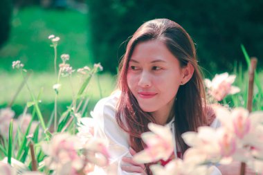 Women are watching the pink orchid in nature