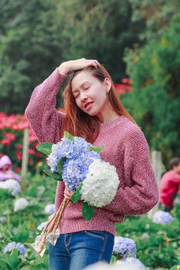 Women standing holding hydrangea flowers in the garden
