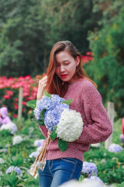 Women standing holding hydrangea flowers in the garden