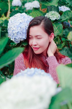 Women sitting in the garden of hydrangea flowers that are blooming