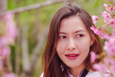 Women are smiling with pink flowers.