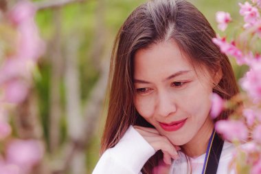 Women are smiling with pink flowers.