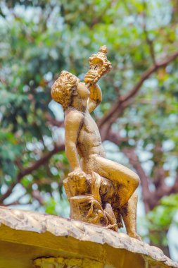 Parkta Çeşme üzerinde altın çocuk heykeli