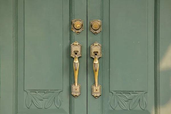 Door Handles Old brass on the green door Used to close or open the door