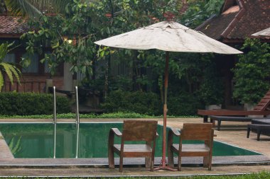 Havuzun yanında iki ahşap sandalye bulunmaktadır..