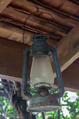 Eski mavi kasırga lambası kiriş üzerinde asılı