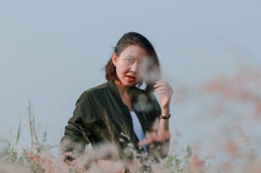 Çim tarlasında sallanan saçları olan bir kadın.