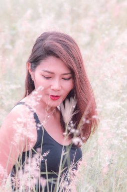 Güzel bir çayırda oturan kadın.