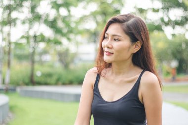 Kadın parkta oturdu ve sevinçle gülümsedi.