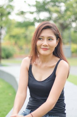 Kadın parkta oturdu ve sevinçle gülümsedi.