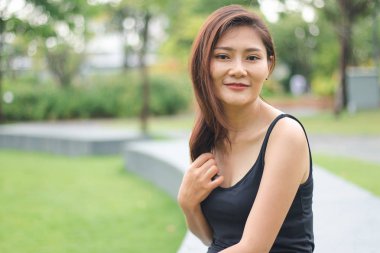 Kadın parkta oturdu ve sevinçle gülümsedi.