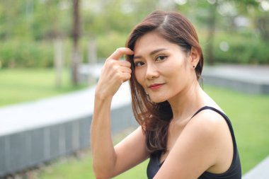 Kadın parkta oturdu ve sevinçle gülümsedi.