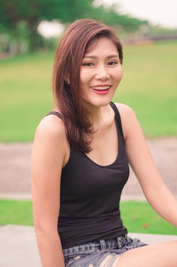 Kadın parkta oturdu ve sevinçle gülümsedi.