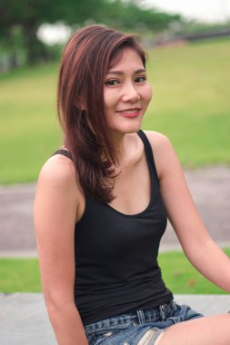 Kadın parkta oturdu ve sevinçle gülümsedi.