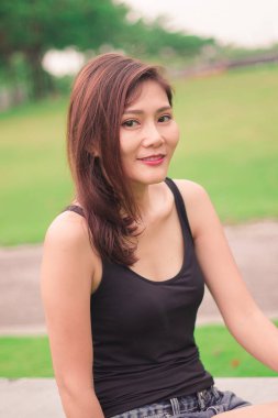 Kadın parkta oturdu ve sevinçle gülümsedi.