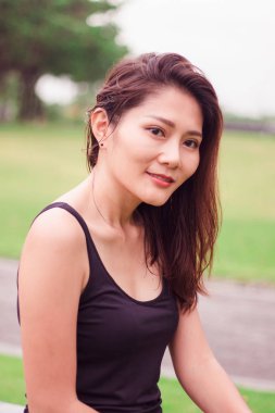 Kadın parkta oturdu ve sevinçle gülümsedi.