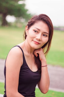 Kadın parkta oturdu ve sevinçle gülümsedi.