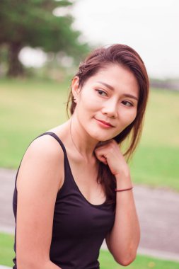 Kadın parkta oturdu ve sevinçle gülümsedi.