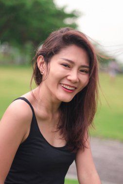 Kadın parkta oturdu ve sevinçle gülümsedi.