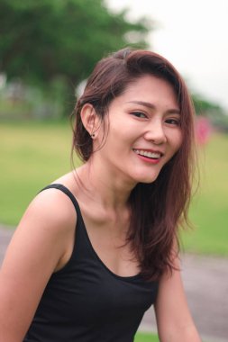 Kadın parkta oturdu ve sevinçle gülümsedi.