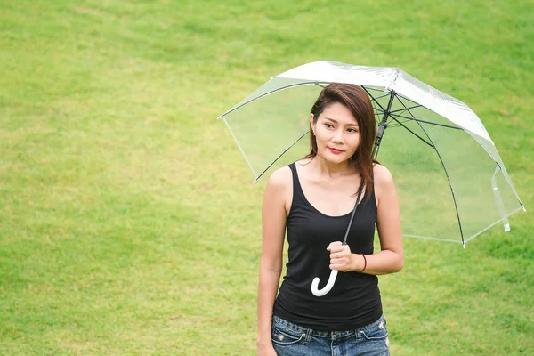 在草坪上的雨伞里行走的妇女 — 图库照片