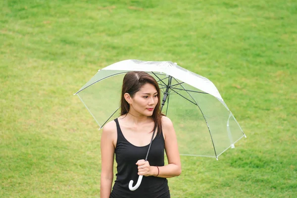 在草坪上的雨伞里行走的妇女 — 图库照片