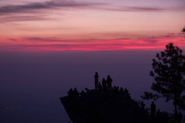 Hafif gündoğumu ile kayalar üzerinde duran Gezginler siluetler.