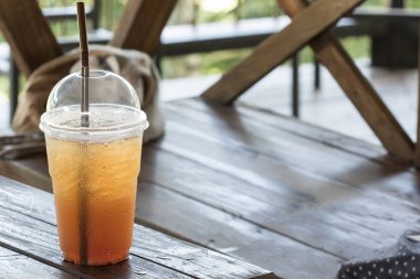 Bir bardak buzlu çay, ahşap bir masaya yerleştirilir