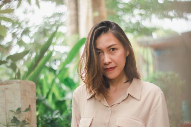 Bahçede poz veren kahverengi gömlek giyen kadınlar