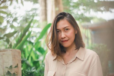 Bahçede poz veren kahverengi gömlek giyen kadınlar