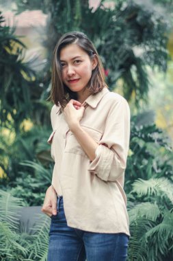 Bahçede poz veren kahverengi gömlek giyen kadınlar