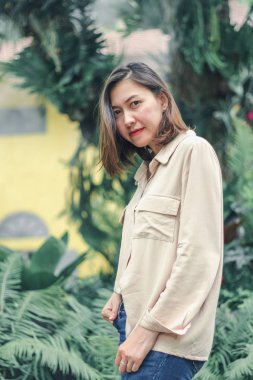 Bahçede poz veren kahverengi gömlek giyen kadınlar