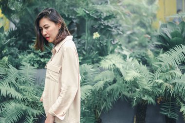 Bahçede poz veren kahverengi gömlek giyen kadınlar