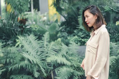 Bahçede poz veren kahverengi gömlek giyen kadınlar