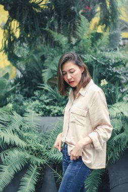 Bahçede poz veren kahverengi gömlek giyen kadınlar