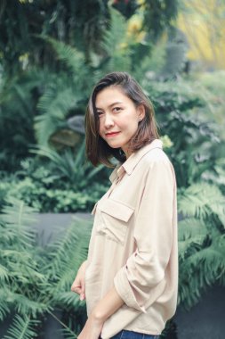 Bahçede poz veren kahverengi gömlek giyen kadınlar